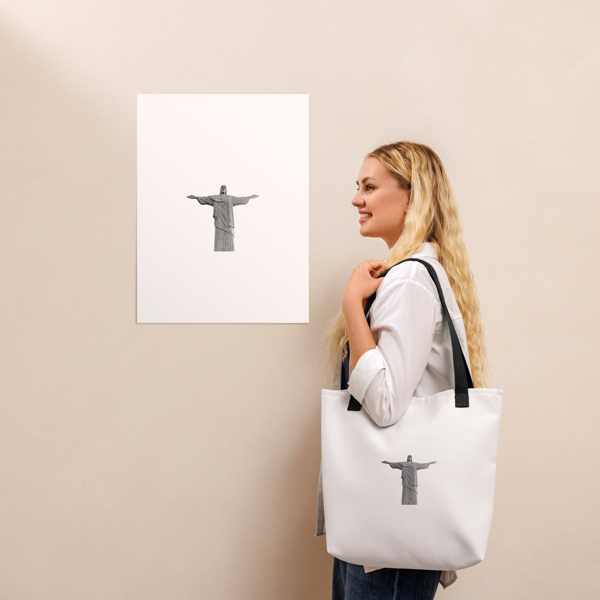 Woman carrying a Christ the Redeemer tote bag 15x15, standing near an art print of Christ the Redeemer.