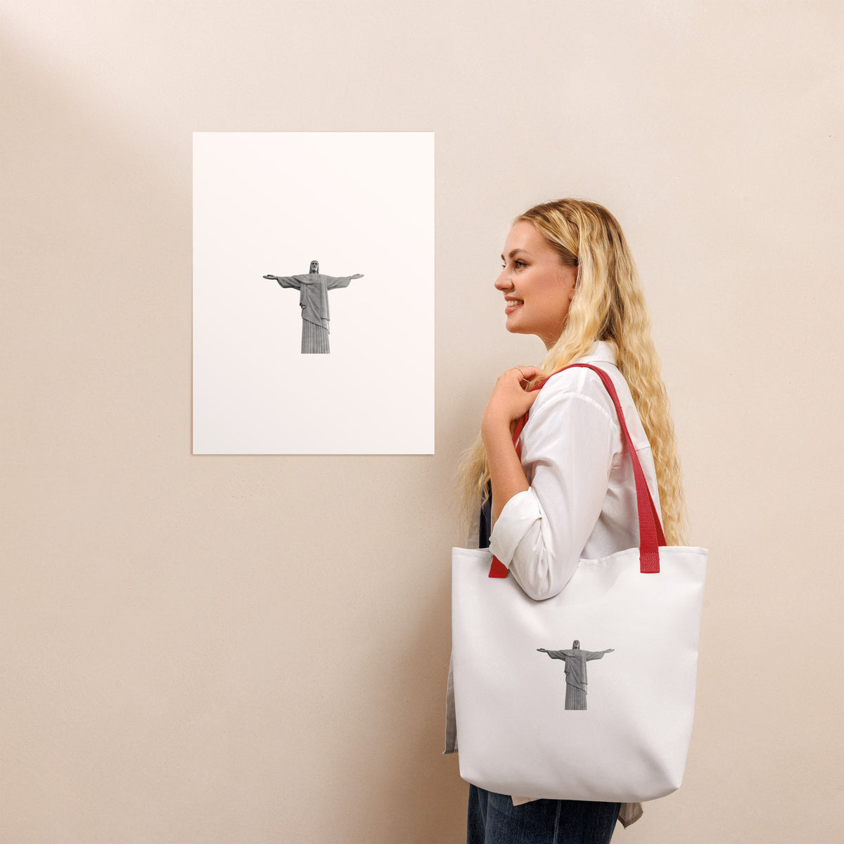 Woman carrying a Christ the Redeemer tote bag 15x15, standing near an art print of Christ the Redeemer.