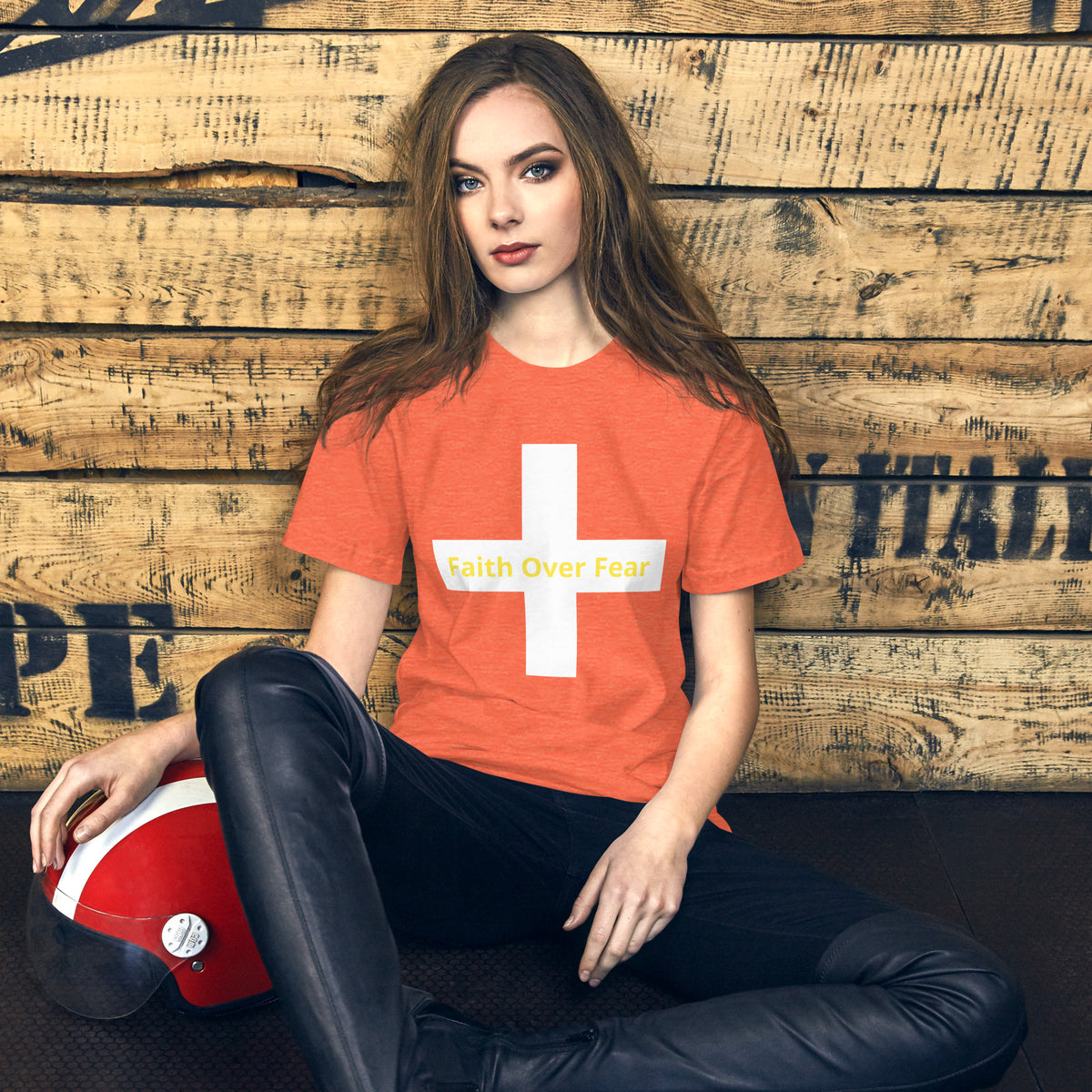 Model wearing a blue Faith Over Fear t-shirt with a cross design, styled with black pants.