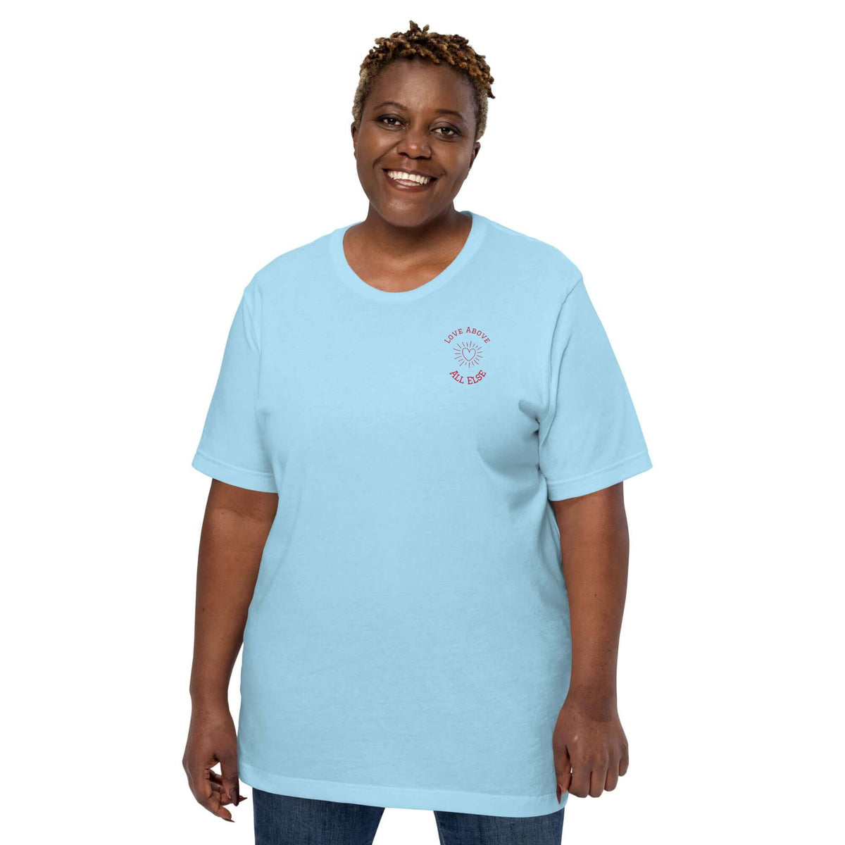 Love Above All Else T-shirt on a smiling woman in light blue, showcasing comfort and casual style.