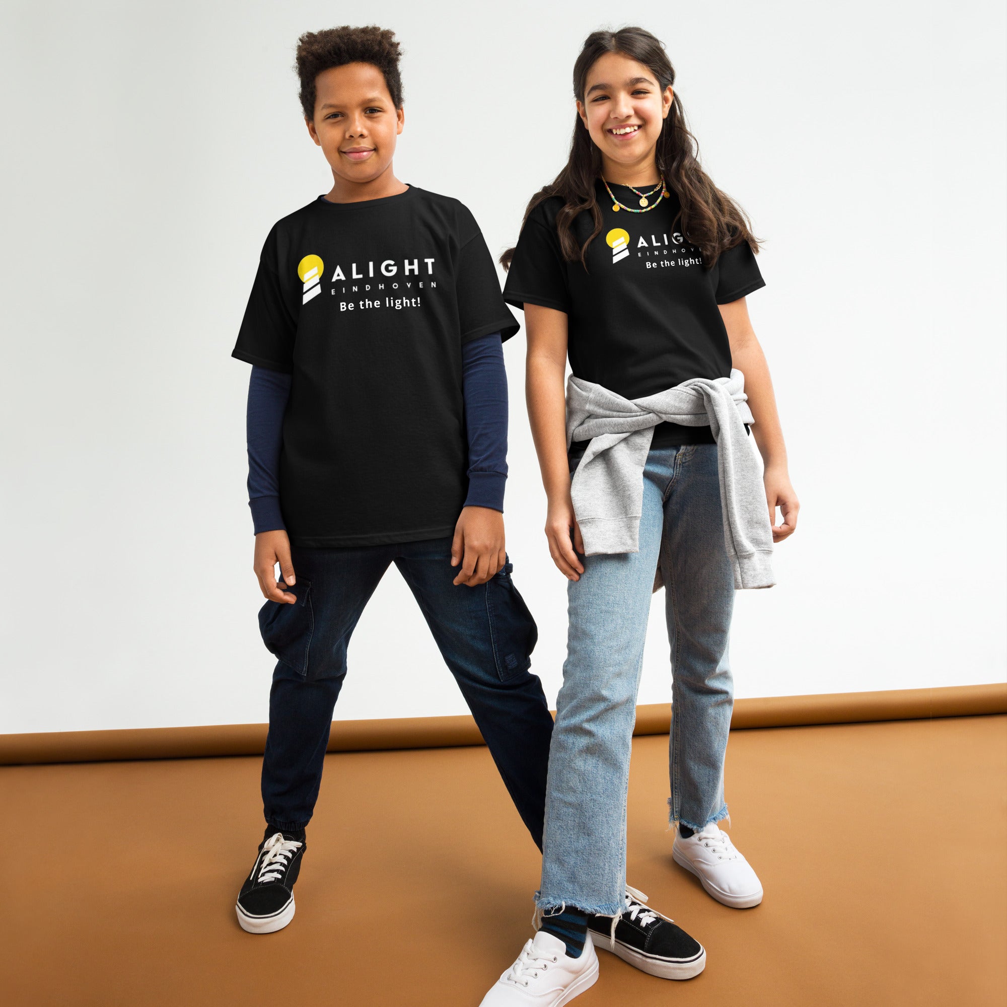 Alight Youth T-shirt worn by kids, showcasing a playful, stylish design that promotes joy and positivity.