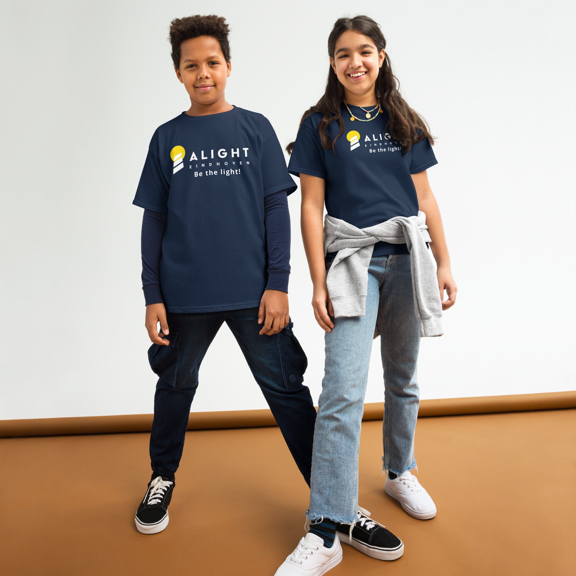 Alight Youth T-shirt worn by kids, showcasing a playful, stylish design that promotes joy and positivity.